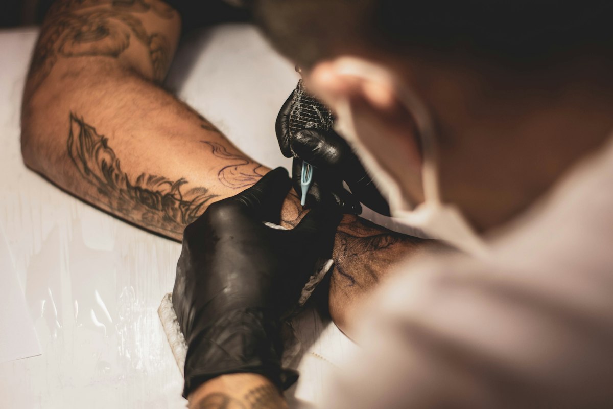 Artista ilustrativo trabalhando em tatuagem — imagem ilustrativa